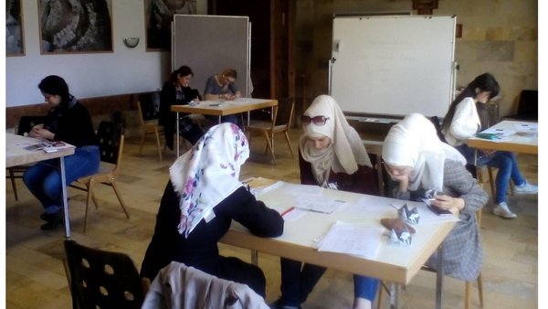 Frauen mit Migrationshintergrund sitzen am Tisch und lernen