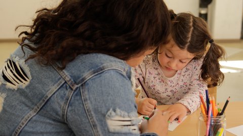 Mädchen und Frau beim Malen mit Buntstiften