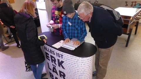 Kinder und Erwachsene am Infostand