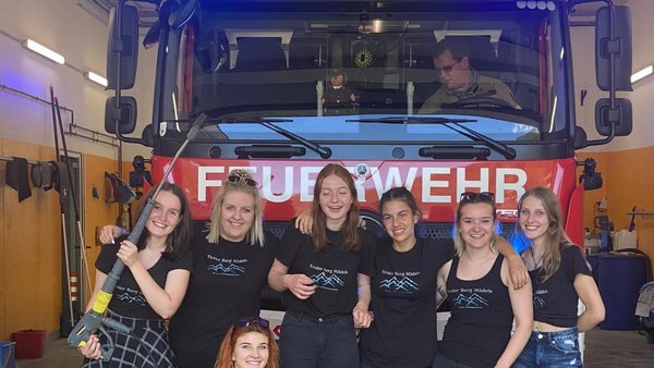 7 Frauen stehen vor einem feuerwehrauto