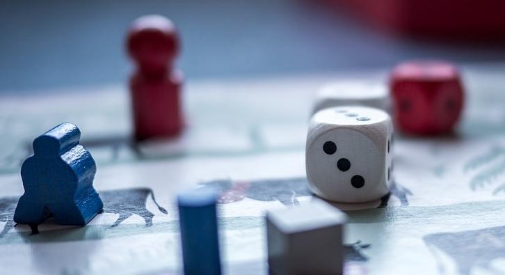 Würfel und Spielfiguren auf einem Spielbrett