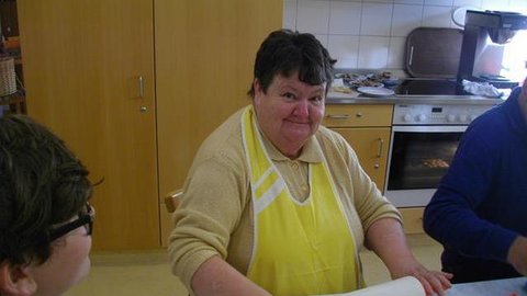 Frau mit gelber Schürze beim Backen