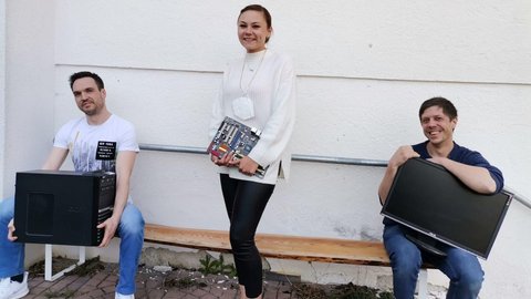 2 Männer und eine Frau halten jeweils einen Bildchirm