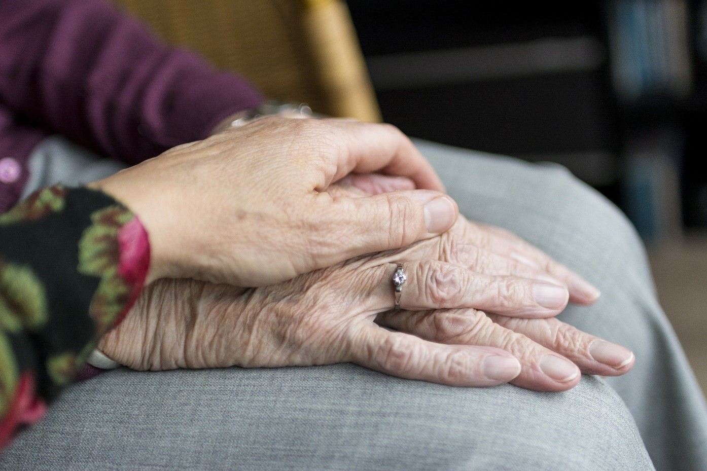 Eine Person hält die Hände einer alten Frau